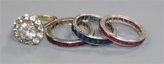 A 9ct gold paste-set ring and three white metal eternity rings, one sapphire and two ruby channel-set (test as platinum)